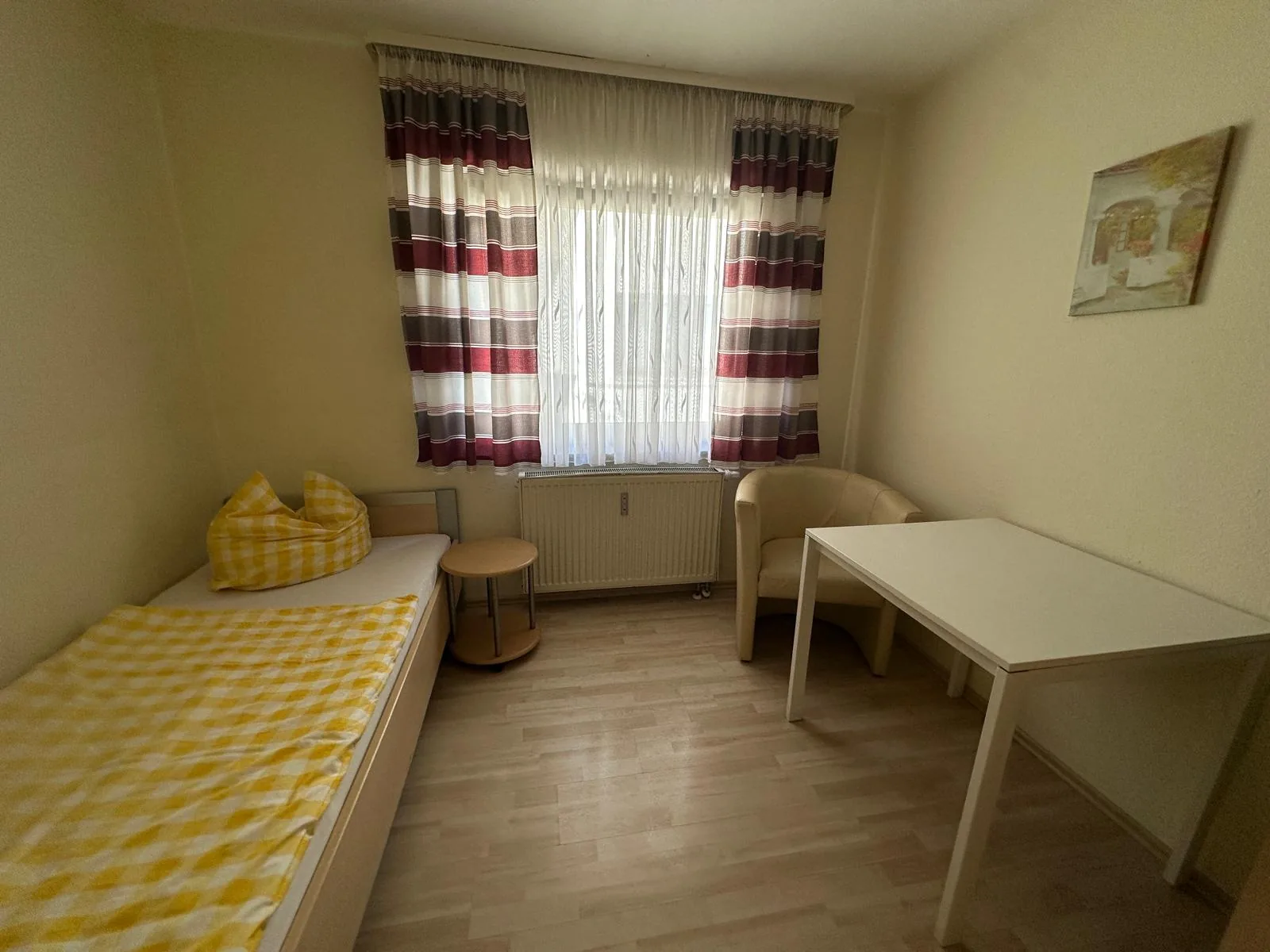 Einzelzimmer mit Bett, Sessel und Schreibtisch in Haus 103 in Gundelsheim Einzelzimmer mit Bett, Sessel und Schreibtisch in Haus 103 in Gundelsheim
